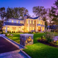 Stone home with all the lights on.