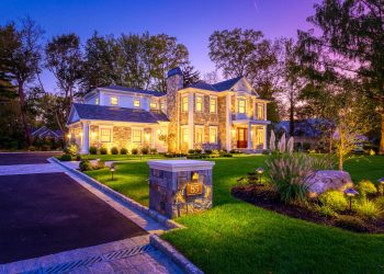 Stone home with all the lights on.