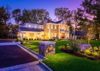 Stone home with all the lights on.