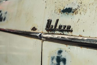 Chrome side trim and emblem on a weathered 1950s Ford Classic Car, Ford, chrome, trim, shiny, weathered, patina, aged, deluxe, americana, automobilia